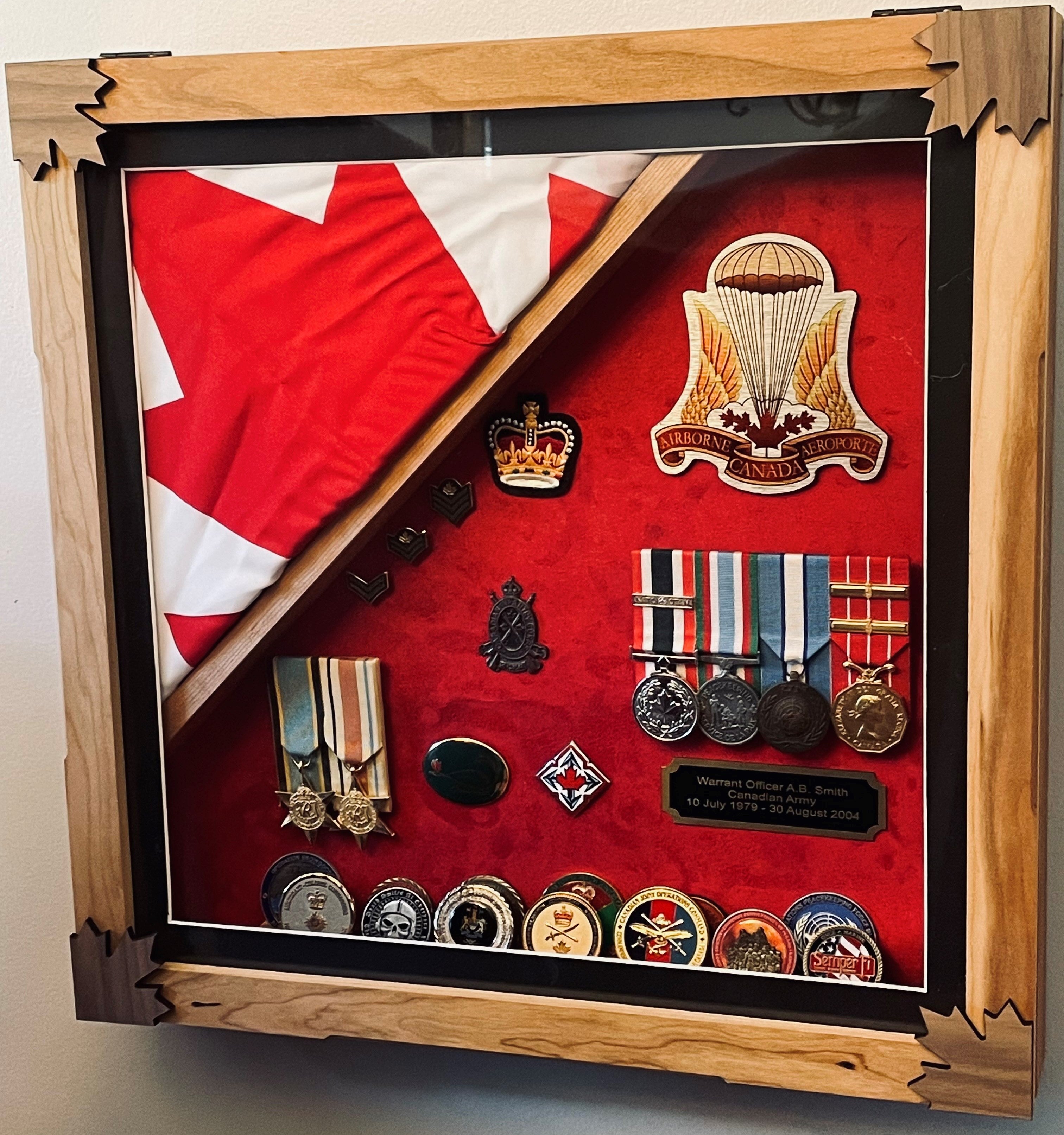 Custom shadow box collection displaying military medals, a flag, and badges on a red background.