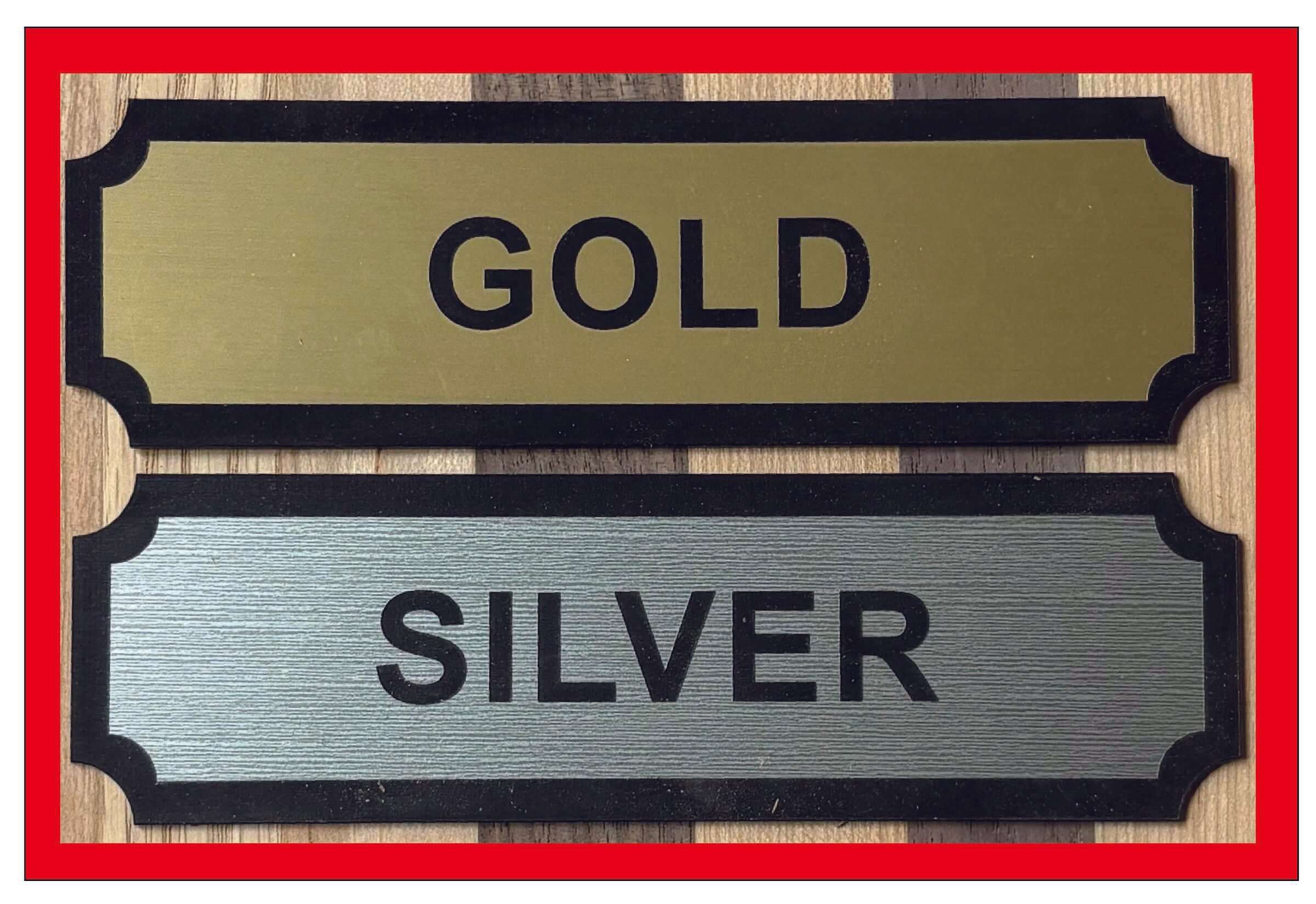 Gold and Silver nameplates displayed on a wooden background, showcasing elegant finishes for labels or markers.